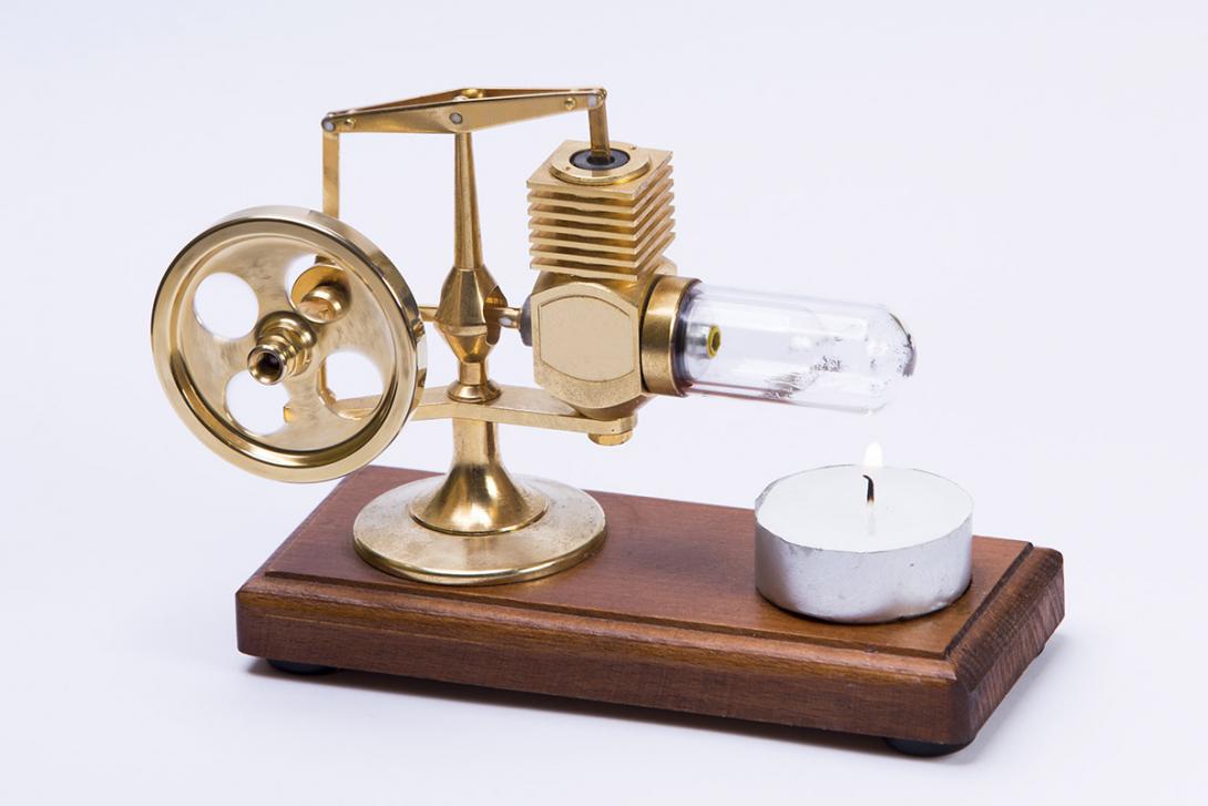 Miniaturní model Stirlingova motoru pracuje při ohřevu vzduchu ve skleněném válci plamenem svíčky (Zdroj: © tamaslaza3 / stock.adobe.com)