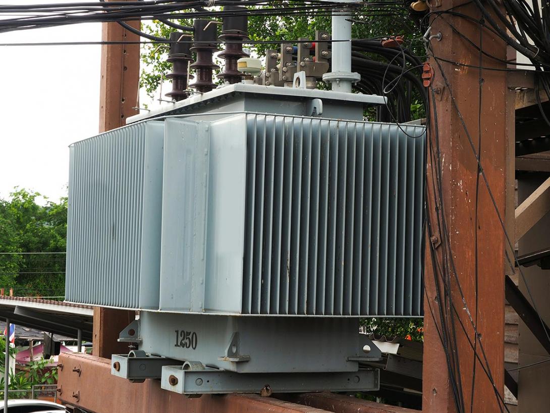 Detail chladicích žeber distribučního transformátoru, umístěného na konzole dvousloupé trafostanice (Zdroj: © Thitinat.K / stock.adobe.com)