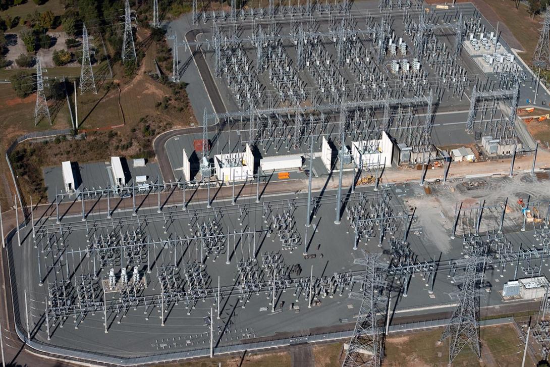 Letecký pohled na elektrickou stanici zahrnující dvě rozvodny a transformovnu, která se nachází uprostřed (Zdroj: © On-Air / stock.adobe.com)