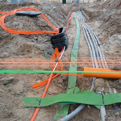 Křižování elektrických distribučních kabelů s optickými telekomunikačními kabely při zasíťování nových pozemků pro výstavbu (Zdroj: © hansenn / stock.adobe.com)