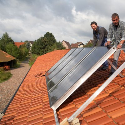 Instalace plochých solárních kolektorů na kovovou konstrukci umístěnou na střeše domu (Zdroj: © Ingo Bartussek / stock.adobe.com)