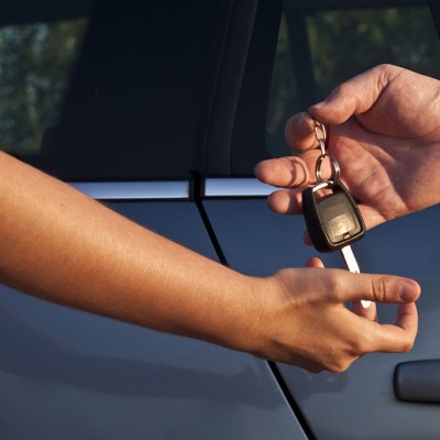 Klíčky od auta se mohou předávat z ruky do ruky, ale častěji jsou uloženy v přihrádce sdíleného vozidla (Zdroj: © mario_vender / stock.adobe.com)