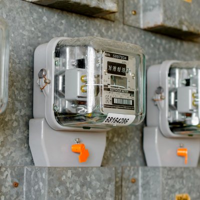 Několik elektrických měřicích přístrojů tvoří odbočky z hlavního domovního vedení do jednotlivých bytů na patře činžovního domu (Zdroj: © weerayut / stock.adobe.com)