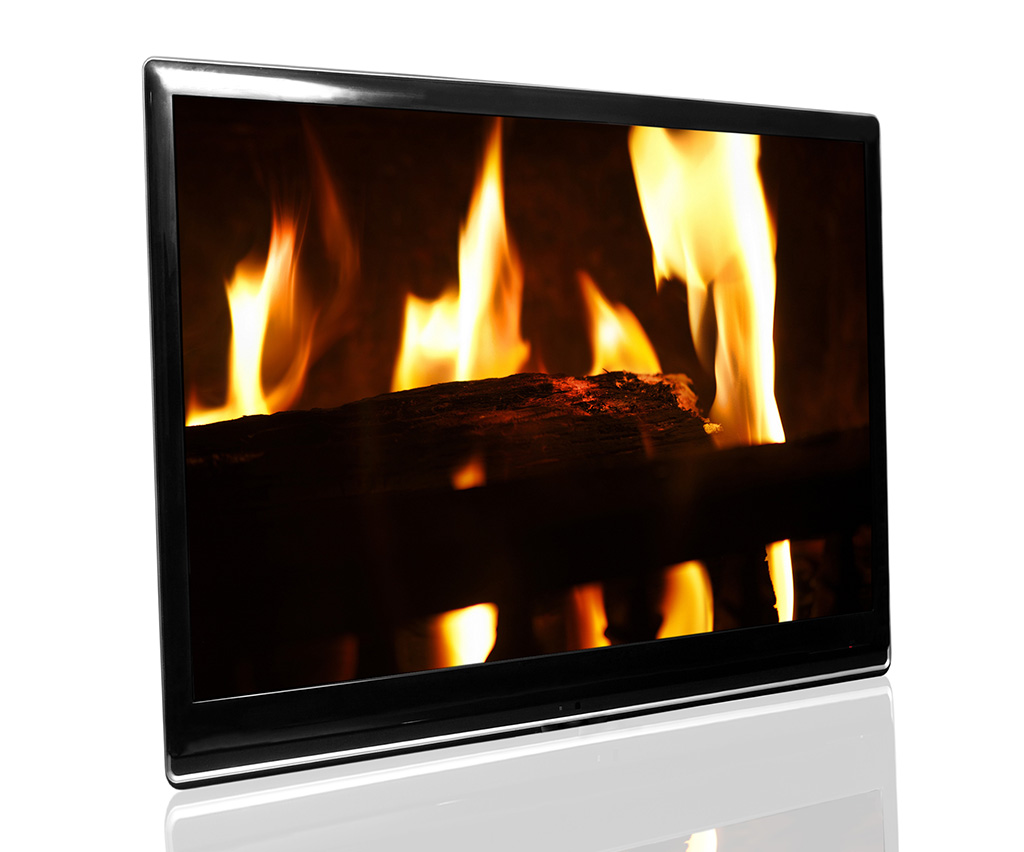 Chytrá televize jako imaginární krb s iluzorním pohledem na hořící a praskající dřevo (Zdroj: © gmstockstudio / stock.adobe.com)