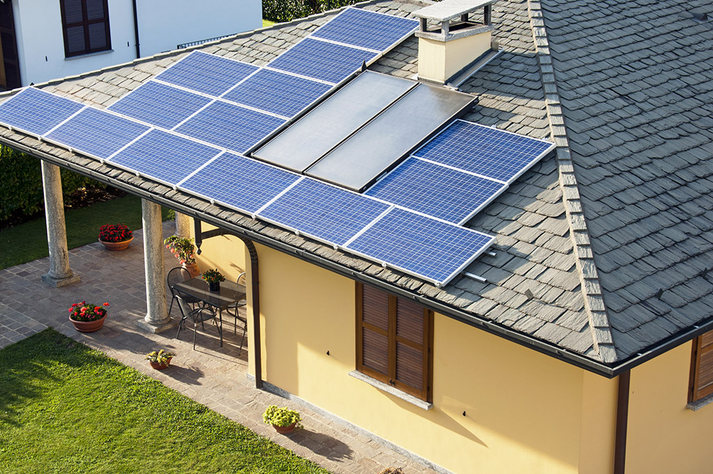 Kombinace solárních termálních a fotovoltaických panelů na střeše rodinného domu (Zdroj: © atm2003 / stock.adobe.com)