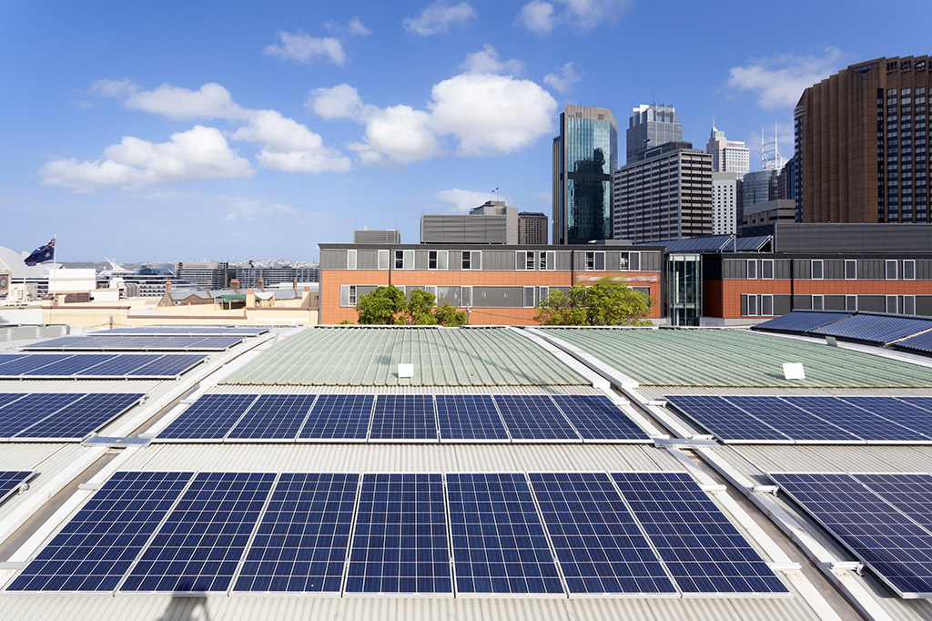 Solární panely umístěné na střeše městské budovy dodávají ekologickou energii pro její provoz (Zdroj: © Gū fēi de hè / stock.adobe.com)